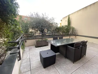 a patio with a table and chairs on a balcony at T3 au pied des Tours du Château in Châteaurenard