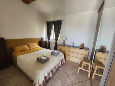 a bedroom with a bed with a suitcase on it at Escapade en maisonnette indépendante avec piscine in Châteaurenard
