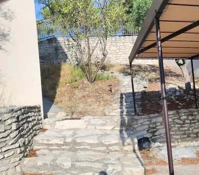 a stone walkway with a tree in a yard at Escapade en maisonnette indépendante avec piscine in Châteaurenard