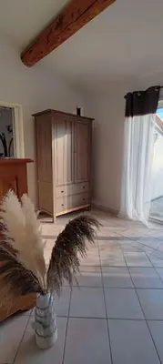 a living room with a cabinet and aumedumed plant at Escapade en maisonnette indépendante avec piscine in Châteaurenard