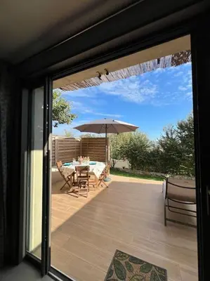 a patio with a table and an umbrella at L'appart du mas du Zébu Bleu in Vernègues