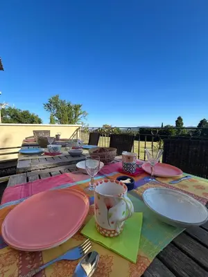 a table with plates and wine glasses on it at Au Clair Ventoux B & B - SPA in Saint-Didier