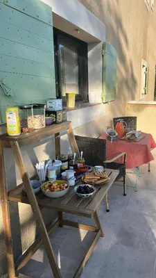 a table with plates of food on a patio at Au Clair Ventoux B & B - SPA in Saint-Didier