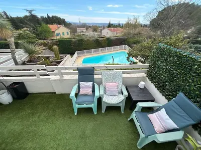 a patio with two chairs and a table and a pool at Magnifique Duplex à proximité Aix en Provence in Éguilles