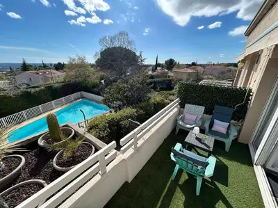 a balcony with a swimming pool and two chairs at Magnifique Duplex à proximité Aix en Provence in Éguilles