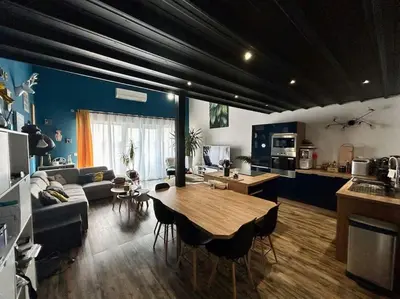 a kitchen and living room with a table and a couch at Magnifique Duplex à proximité Aix en Provence in Éguilles