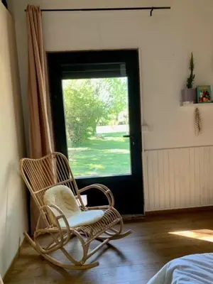 a rocking chair in a bedroom with a window at House with swimming pool and breathtaking views of the Luberon in Robion en Luberon