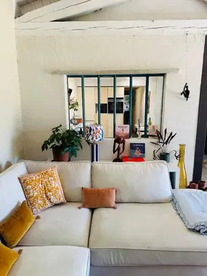 a living room with a white couch with pillows at House with swimming pool and breathtaking views of the Luberon in Robion en Luberon
