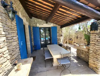a patio with a table and chairs and blue doors at 