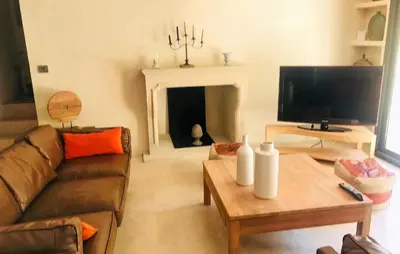 a living room with a couch and a table with a fireplace at Lovely Home In Le Thor With Wifi in Le Thor