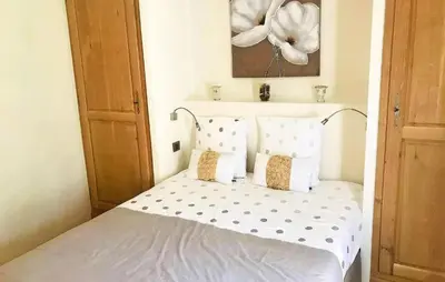 a bedroom with a bed with white sheets and a flower painting at Lovely Home In Le Thor With Wifi in Le Thor