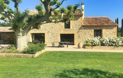 a stone house with a picnic table in a yard at Lovely Home In Le Thor With Wifi in Le Thor