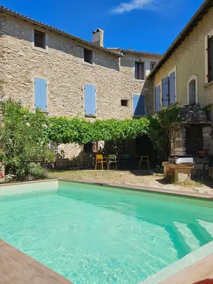 an outdoor swimming pool in front of a building at Maison provençale, piscine, calme et Lubéron in Le Thor