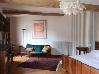 a bedroom with a bed and a couch and a chair at Maison provençale, piscine, calme et Lubéron in Le Thor