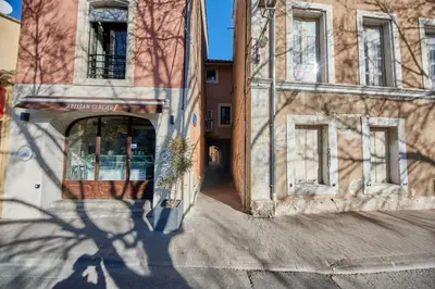 a shadow of a building on the side of a street at Studio5 proche Quai Rouget in LʼIsle-sur-la-Sorgue