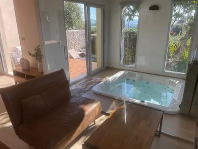 a living room with a hot tub in a glass table at logement avec jacuzzi in Joucas