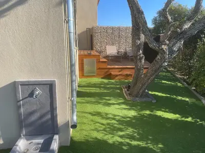 a yard with green grass and a tree at logement avec jacuzzi in Joucas
