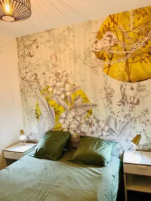 a bedroom with a bed with a floral wall at Rotonde, 2 chambres, Air conditionné in Aix-en-Provence