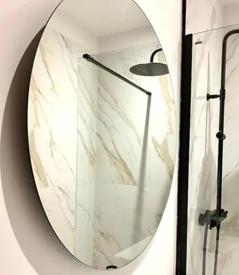 a circular mirror on a wall with a shower at Rotonde, 2 chambres, Air conditionné in Aix-en-Provence