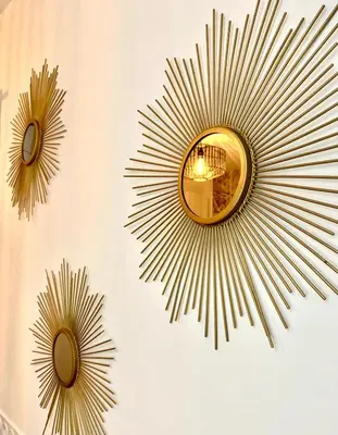 a wall with two mirrors and a sunburst mirror at Rotonde, 2 chambres, Air conditionné in Aix-en-Provence