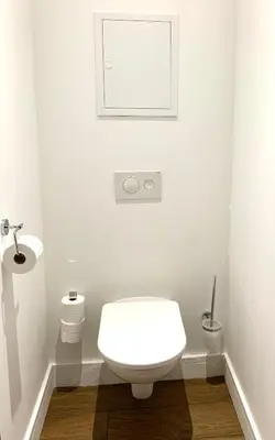 a white bathroom with a toilet and a picture on the wall at Rotonde, 2 chambres, Air conditionné in Aix-en-Provence