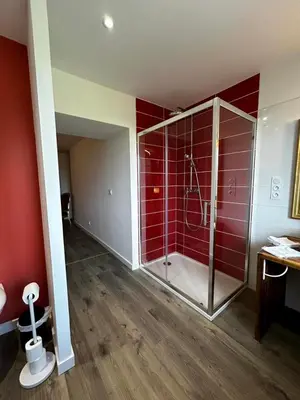 a bathroom with a shower with red tile at Logis du Vert Moulin Premium in Le Puy-Sainte-Réparade