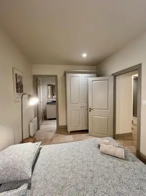a bedroom with a bed and a chair and a kitchen at Appartement au coeur du centre historique in Aix-en-Provence