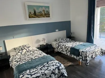 a bedroom with two beds and a painting on the wall at Villa les trois pins in Venelles