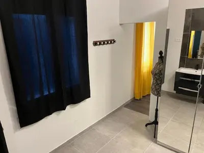 a bathroom with a black shower curtain and a mirror at Villa les trois pins in Venelles