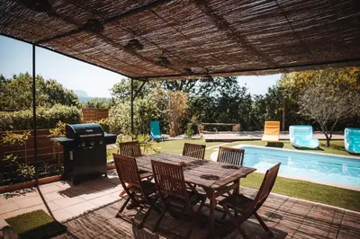 a patio with a table and chairs and a grill at Villa les trois pins in Venelles