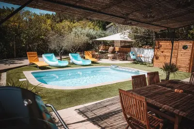 a swimming pool in a yard with chairs and a table at Villa les trois pins in Venelles