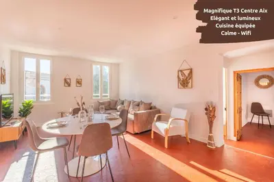 a living room with a table and a couch at Le Saint Sauveur - Centre Ville - Calme - Lumineux in Aix-en-Provence