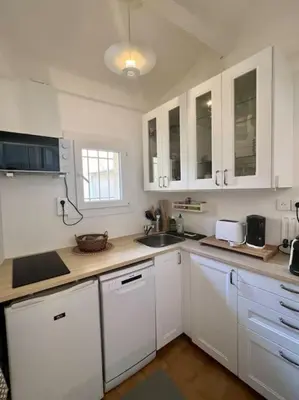 a kitchen with white cabinets and a sink at Terrasse à Aix en Provence centre historique in Aix-en-Provence