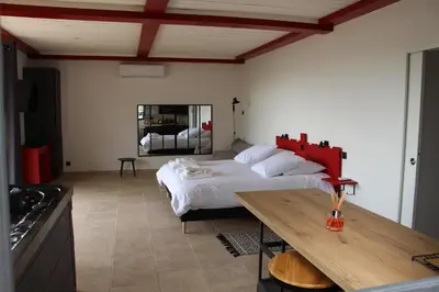 a bedroom with a large bed and a wooden table at Ferme de restantier, love room in La Tour-dʼAigues