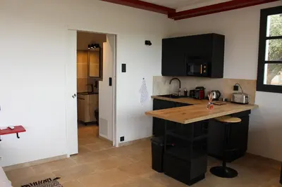 a kitchen with black cabinets and a wooden counter top at Ferme de restantier, love room in La Tour-dʼAigues