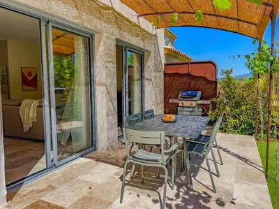 a table and chairs on a patio with a grill at Villa Lisette, un meublé de tourisme 3 étoiles au cœur de Goult in Goult