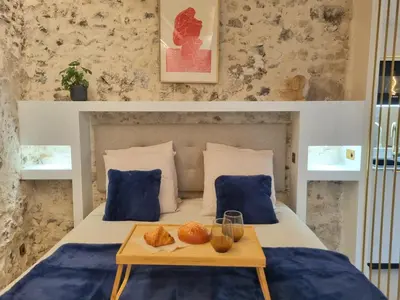 a bed with a tray of food on it at 25 rue Celony - Le Vendome - Jacuzzi - VideoProjecteur in Aix-en-Provence