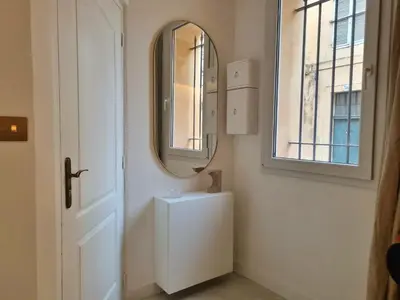 a white bathroom with a mirror and a sink at 25 rue Celony - Le Vendome - Jacuzzi - VideoProjecteur in Aix-en-Provence