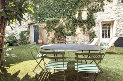 a table and chairs sitting in a yard at Maison Ange & Lice in Pernes-les-Fontaines