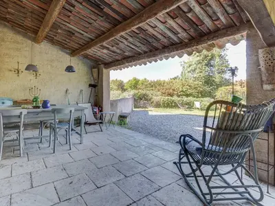 a patio with a table and chairs on a patio at Cottage in Oppède with Pool and Garden in Maubec