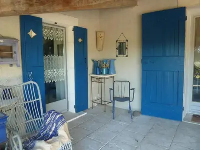 a room with blue doors and a table and a chair at Cottage in Oppède with Pool and Garden in Maubec