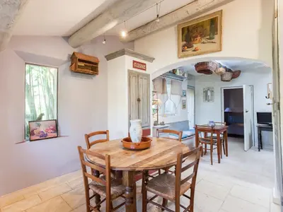 a kitchen and dining room with a wooden table and chairs at Cottage in Oppède with Pool and Garden in Maubec