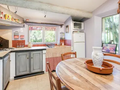 a kitchen with a wooden table and a dining room at Cottage in Oppède with Pool and Garden in Maubec