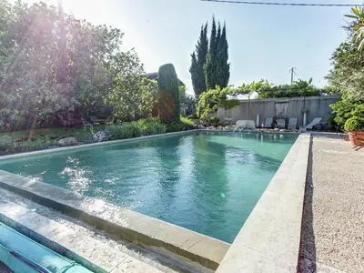 a swimming pool in a backyard with trees and bushes at Charming Cottage in Oppède amidst Vineyards in Maubec