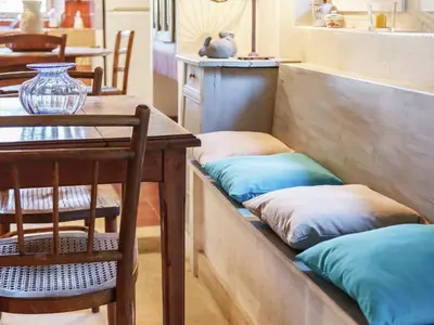 two pillows sitting on a bench next to a table at Charming Cottage in Oppède amidst Vineyards in Maubec