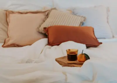 a tray with a cup of coffee and an apple on a bed at Logement de Charme vue Luberon - Rez-de-chaussée de maison, Jardin & Piscine in La Tour-dʼAigues