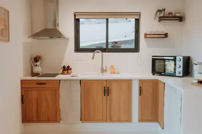 a kitchen with a sink and a microwave at Logement de Charme vue Luberon - Rez-de-chaussée de maison, Jardin & Piscine in La Tour-dʼAigues