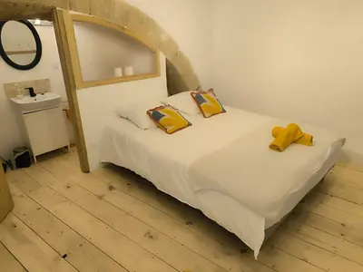 a bedroom with a bed with two yellow bows on it at Les studettes du Beffroi in Cucuron