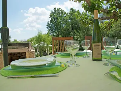 a table with a bottle of wine and glasses at Holiday Home Provence with Pool in Céreste