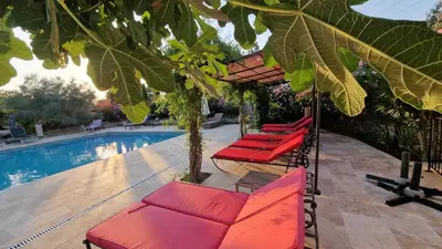 a group of red lounge chairs next to a pool at Moulin AURELIA - chambre La Coloniale in Pélissanne